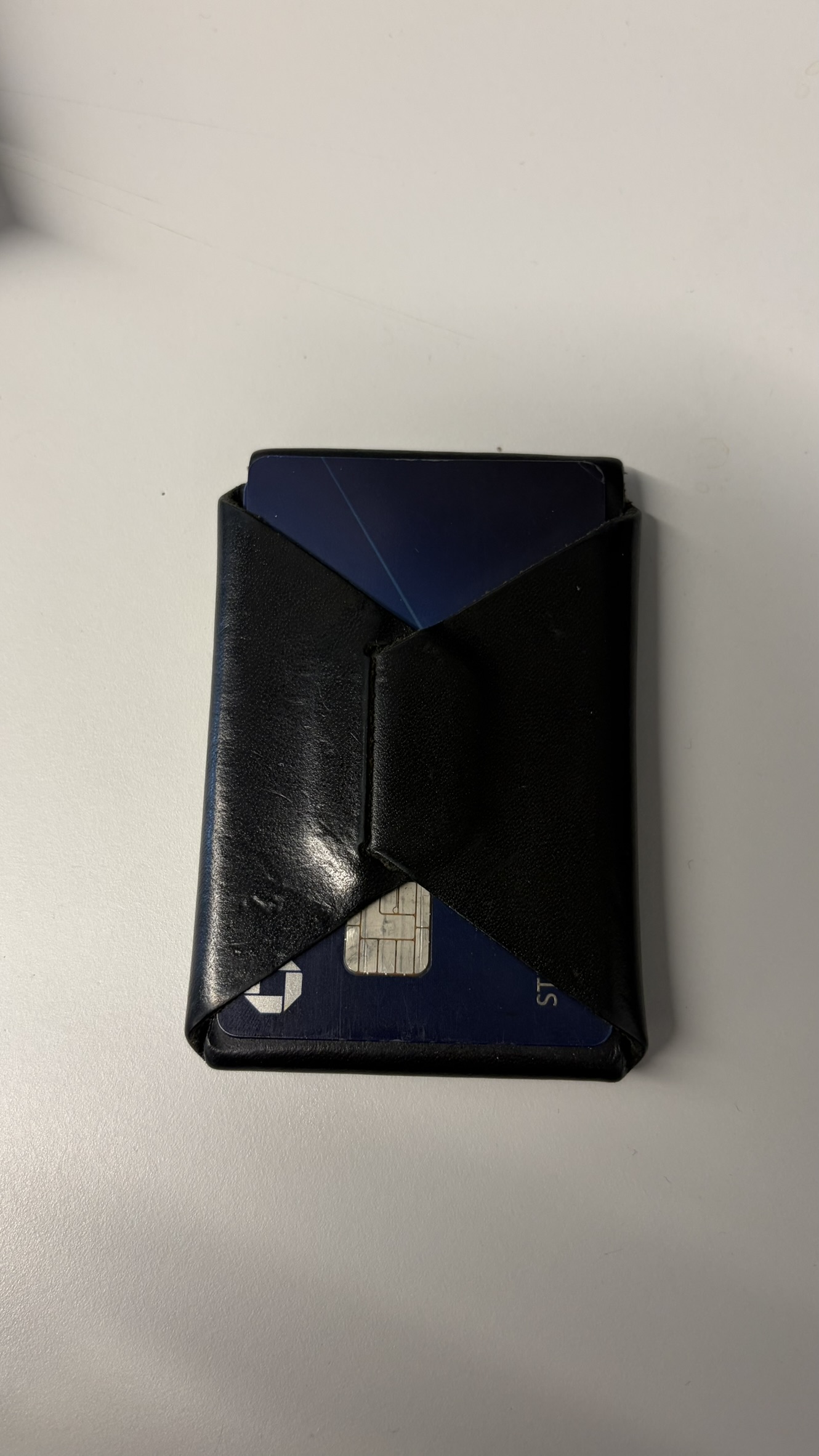 Front of black leather wallet showing stitchless fold construction